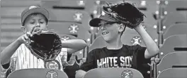  ?? CHRIS SWEDA/CHICAGO TRIBUNE ?? Young Chicago fans compare gloves before a game at Guaranteed Rate Field.