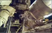  ?? NASA VIA AP ?? Astronauts Andrew Morgan and Nick Hague (not seen) begin Wednesday to install a docking port delivered by SpaceX last month outside the Internatio­nal Space Station.