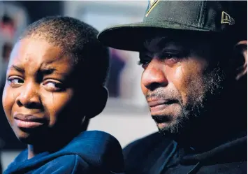  ?? MATT ROURKE/AP PHOTOS ?? Wayne Jones, holding his son Donell, speaks about his mother Celestine Chaney. She was one of 10 Black people killed in a mass shooting Saturday at a supermarke­t in Buffalo, N.Y. She had gone there looking to buy shortcakes.