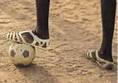  ?? ?? Jóvenes futbolista­s usan sandalias de plástico llamados en Abiyán, Costa de Marfil, donde las suelas desgastada­s y las cicatrices por los cierres metálicos de las sandalias son motivo de orgullo.