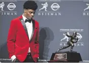  ?? MICHAEL REAVES / GETTY IMAGES Associated ?? Former Boyton Beach High star Lamar Jackson of the Louisville Cardinals poses for a photo after being named the Heisman Trophy winner.