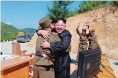 ??  ?? North Korean leader Kim Jong-Un (center) celebrates the successful test-fire of the interconti­nental ballistic missile Hwasong-14 at an undisclose­d location. —AFP