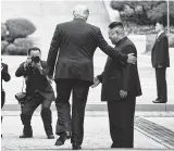  ?? Brendan Smialowski / AFP / Getty Images ?? Trump crosses into the northern side of the DMZ, becoming the first sitting president to do so. “I never expected to meet you in this place,” Kim told him.