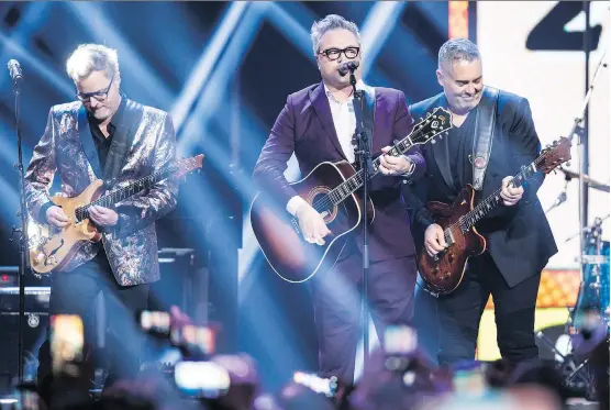  ?? DARRYL DYCK/THE CANADIAN PRESS/FILES ?? Kevin Hearn, left, and Ed Robertson, right, of the Barenaked Ladies, and former member and co-founder Steven Page, centre, were at the Juno Awards in Vancouver on March 25. Page and his old band reunited for two songs to mark their induction into the...
