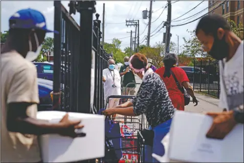  ??  ?? Residents line up at a food distributi­on site at St. Sabina Catholic Church in the Auburn Gresham neighborho­od in Chicago. (AP/David Goldman)