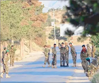  ?? AFP ?? Afghan soldiers stand guard along a road following an attack on a lakeside hotel in Kabul yesterday.