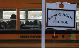  ?? Carlo Allegri/Reuters ?? A school bus drives past a Sandy Hook school sign in Newtown, Connecticu­t. Photograph: