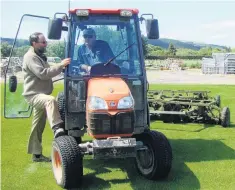  ??  ?? Mowing three times a week during springkeep­s the Readylawn turf immaculate. Turfmanage­r Ivan Luscombe on themower takes a break to discuss progress with Fred Doherty.