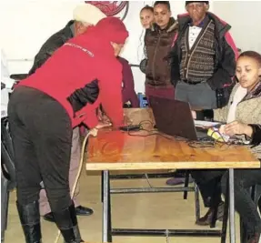  ?? Picture: DESMOND COETZEE ?? AT YOUR SERVICE: Sassa official Sinayo Nqokoqa assists pensioners at the Breidbach community hall on Tuesday