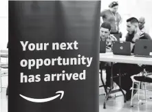  ?? Arnold Gold / Hearst Connecticu­t Media ?? Michael Conroy, center, of New Haven, Conn., gets assistance from Christian Ortiz during an Amazon Job Fair. A federal jobs report due Friday may influence Fed interest-rate decisions.