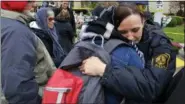  ?? GENE J. PUSKAR - THE ASSOCIATED PRESS ?? Pittsburgh Police officer Sarah Pratt gets a hug before a Shabbat morning worship service led by Rabbi Chuck Diamond outside the Tree of Life Synagogue Saturday in Pittsburgh. About 100 people gathered in a cold drizzle for what was called a “healing service” outside the synagogue that was the scene of a mass shooting a week ago.