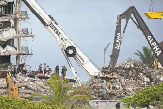  ?? Emily Michot / Associated Press ?? A ramp built overnight allows rescuers to use a crane on sections that were not previously accessible. It improves the chances of finding new pockets of space in the search for survivors.