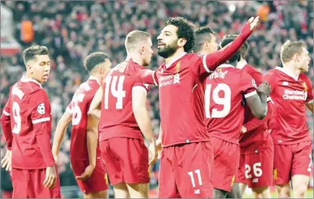  ?? AFP ?? Liverpool midfielder Mohamed Salah (centre) celebrates with teammates after scoring his side’s first goal in their Champions League quarterfin­al first leg with Manchester City at Anfield on Wednesday night.