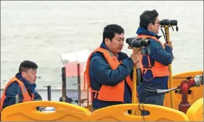  ?? XINHUA ?? Researcher­s from the Yangtze Fishery Administra­tion Office watch finless porpoises as part of a protection project.