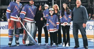  ?? AP ?? TROU’ BLUE: Jacob Trouba, who was nominated for the King Clancy Memorial Trophy for his humanitari­an contributi­ons, poses with Jonathan Quick and his family.