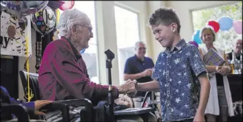  ?? Rachel Aston Las Vegas Review-Journal @rookie__rae ?? Joe Vosicky, 7, says happy birthday to Gene Stephens at his 100th birthday party July 12 at Atria Seville Senior Living in Las Vegas.