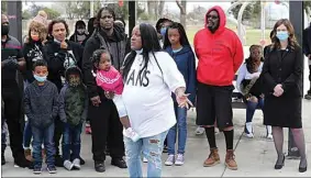  ??  ?? La Sheka Hendrix holds onto her granddaugh­ter while speaking during a prayer vigil held Wednesday at Wayside Park for her daughter Sha Neva Riley, who was shot and killed at the park last weekend.