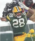  ?? MARK HOFFMAN / MILWAUKEE JOURNAL SENTINEL ?? Green Bay Packers running back AJ Dillon tries a Lambeau Leap in the snow after a 30-yard touchdown run during the third quarter Sunday.