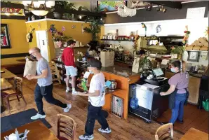  ?? PHOTOS BY SHERRY LAVARS — MARIN INDEPENDEN­T JOURNAL ?? A customer heads out with a to-go order at Taquería and Pupusería El Torogoz in Larkspur.