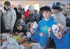  ??  ?? Children show off their reusable Easter pouches.