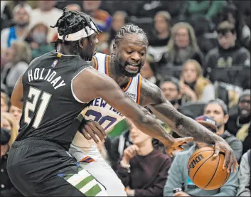  ?? The Associated Press ?? Morry Gash
Knicks forward Julius Randle tries to get by Bucks guard Jrue Holiday in the first half of New York’s 113-98 victory Friday at Fiserv Forum. Randle scored 32 points.