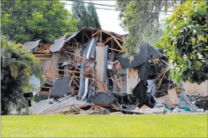  ?? Alessandra da Pra ?? The Associated Press Debris is strewn about from a partially collapsed home in Land O’ Lakes, Fla., on Friday. A sinkhole that started out the size of a small swimming pool and continued to grow swallowed one home and 80 percent of the one shown.