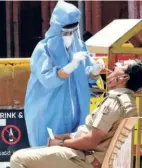  ??  ?? HEALTH workers collecting swab from a policeman at KR Market in Bengaluru on June 23.