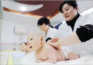  ?? AFP ?? Medical staff massage babies at an infant care centre in Yongquan, in Chongqing municipali­ty, in southwest China, in 2016.