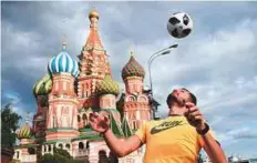  ?? AFP ?? A man shows off his skills with a football in front of the Saint Basil’s Cathedral on the Red Square in Moscow.