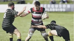  ??  ?? 0 George Arnott, centre, tries to make a break for Stirling County.