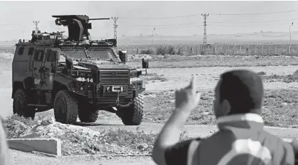  ?? LEFTERIS PITARAKIS/AP ?? An armored Turkish police vehicle patrols the Turkey-Syria border on Saturday.