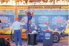  ?? TONY GUTIERREZ/ASSOCIATED PRESS ?? Scott Dixon, center, steps out of the cockpit and onto his car in Victory Lane after winning Saturday’s IndyCar race at Texas Motor Speedway. At left is car owner Chip Ganassi.