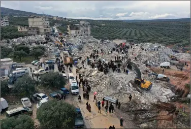  ?? (AP/Ghaith Alsayed) ?? Civil defense workers and residents search through the rubble of collapsed buildings in the town of Harem near the Turkish border on Monday.