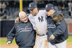  ?? ROBERT DEUTSCH, USA TODAY SPORTS ?? Trainer Steve Donohue, left, and manager Joe Girardi help Derek Jeter off the field Saturday after the Yankees captain broke his left ankle in Game 1.