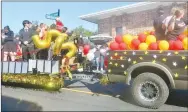  ?? Westside Eagle Observer/SUSAN HOLLAND ?? Members of the sophomore class at Gravette High School ride on a float lined with strips of film in the annual football homecoming parade. Their float was pulled by a star-studded pickup, all in keeping with the parade’s theme, “Lights, Camera, Action.”