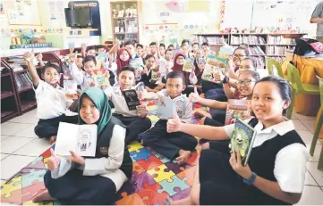  ??  ?? Children of SK Serayan Keranji in Lundu enjoy reading the wide variety of books contribute­d by iM Sarawak.