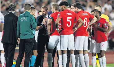  ?? PHOTO: REUTERS2 ?? Time out . . . The England players and manager Gareth Southgate (fourth left) speak to referee Ivan Bebek (third left) as the Euro 2020 qualifying match against Bulgaria in Sofia yesterday is stopped during the first half. England won 60.