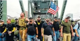  ?? AP PHOTO/NOAH BERGER ?? Members of the Proud Boys and other right-wing demonstrat­ors march across the Hawthorne Bridge during an “End Domestic Terrorism” rally in Portland, Ore., on Saturday.