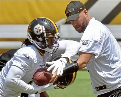  ?? Matt Freed/Post-Gazette ?? Above: Steelers quarterbac­k Ben Roethlisbe­rger hands off to rookie running back Najee Harris, the team’s top draft pick, during minicamp Tuesday at Heinz Field. Left: Steelers tight end Eric Ebron reacts to a teammate’s play during drills. See coverage of the minicamp in Sports,