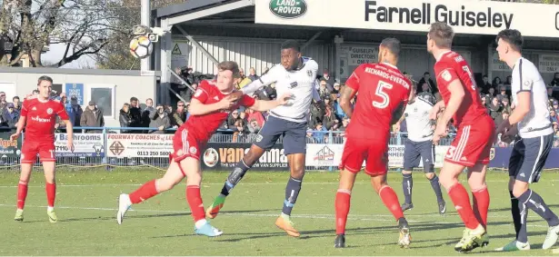  ?? Simon Hall ?? Stanley come under pressure as Guiseley striker Kayode Odejayi sends a header goalward at Nethermoor Park in the FA Cup first round tie