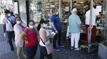  ?? MARK LENNIHAN — THE ASSOCIATED PRESS ?? In a June 8 photo, people wearing face masks stand in line to enter a Sneaker Box after it reopens in the Bronx.