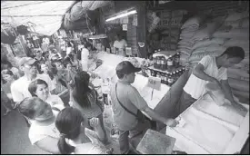  ?? MICHAEL VARCAS ?? People line up for NFA rice at the Commonweal­th market in Quezon City yesterday.