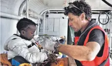  ?? FOTO: SEA EYE ?? Jan Ribbeck versorgt ein Kleinkind während einer Rettungsmi­ssion auf einem Sea- Eye-Schiff im Mittelmeer.