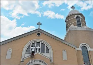  ?? TIM MARTIN THE DAY ?? Carlos Castro of New London, an employee of Mysticbase­d Atlantic Painting, scrapes away weathered window sealant materials in order to re-glaze windows on the Saint Sophia Hellenic Orthodox Church in New London on Wednesday. Atlantic Painting, owned by...