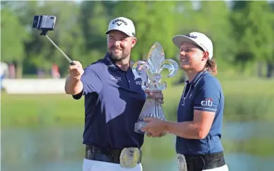  ?? GERALD HERBERT/AP ?? Marc Leishman, left, and teammate Cameron Smith hold the trophy after winning the PGA Zurich Classic on Sunday at TPC Louisiana.