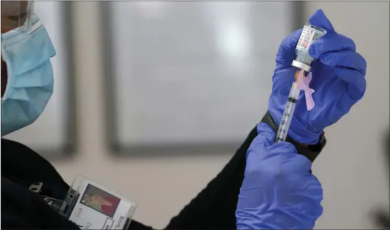  ?? THE ASSOCIATED PRESS A nurse prepares a COVID-19 vaccine. ??