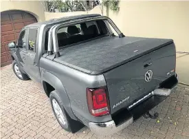  ??  ?? Above: The new secure tonneau cover keeps cargo in the load bin away from prying eyes. The interior, above right, still provides that great balance between bakkie and car comfort. The badge that signals the power within, left.