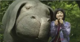  ?? THE ASSOCIATED PRESS ?? Seo-Hyun Ahn as Mija and the character Okja in a scene from the South Korean film “Okja.” There is an interest in adding very young female heroes to the U.S. cultural milieu.