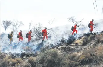  ?? Nikolas Samuels/The Signal ?? Firefighte­rs walk through smoke to help extinguish a fire that ignited on Wednesday.