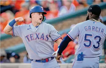  ?? Andrew Harnik/Associated Press ?? A solo home run by Josh Jung, left, in the sixth inning proved to be the difference as the Rangers took Game 1 for their third consecutiv­e playoff victory without a loss this year.